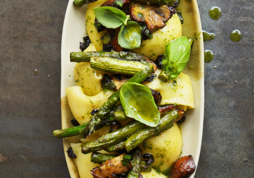 Lumaconi mit grünem Spargel, gerösteten getrockneten Tomaten, Pilzen und selbstgemachtem Basilikumöl